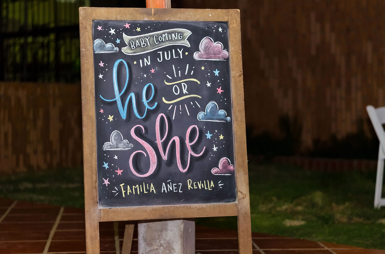 A colorful Gender Reveal Sign that reads "Baby coming in July: He or She?"